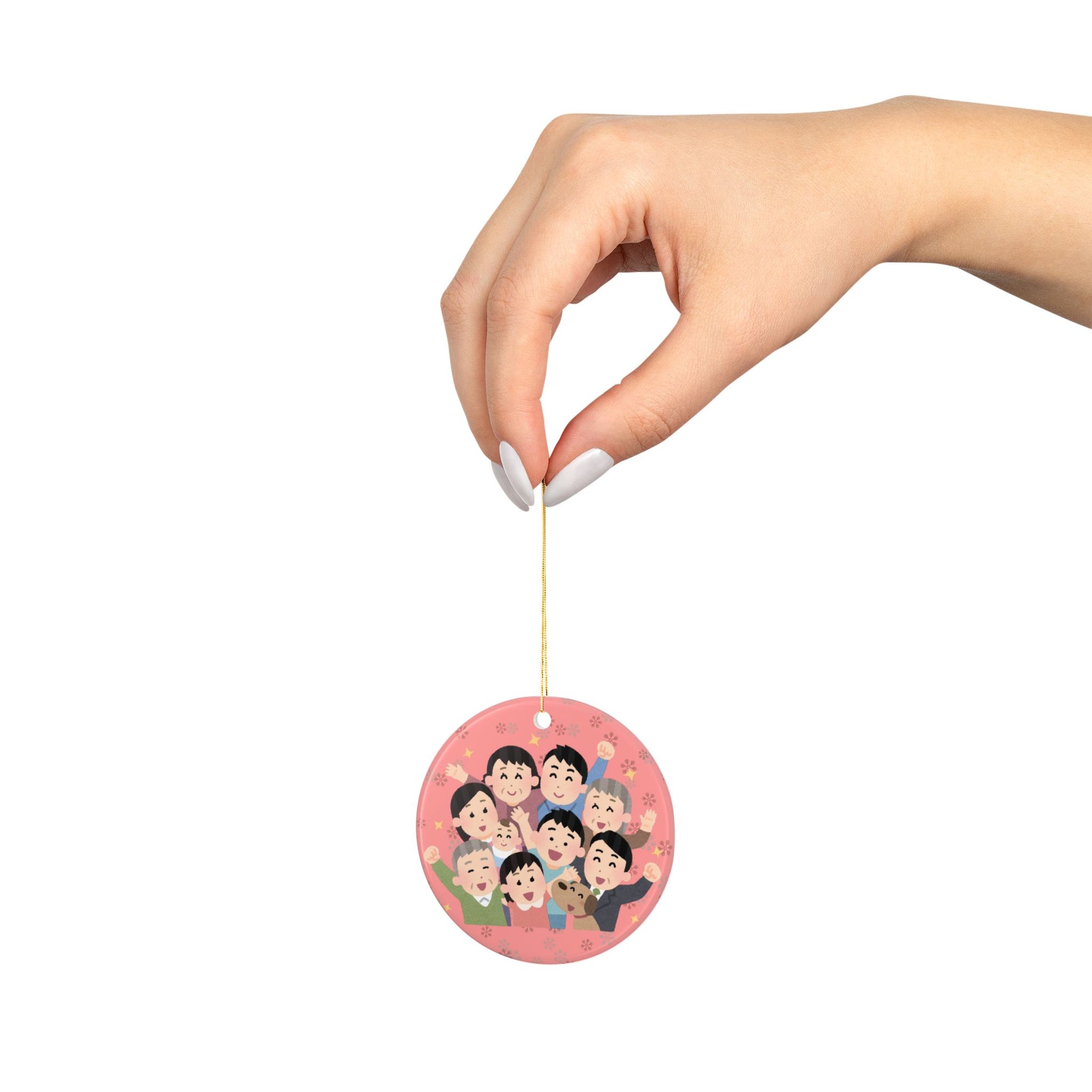 Round red ornament with cartoon characters family held by a hand on a white background