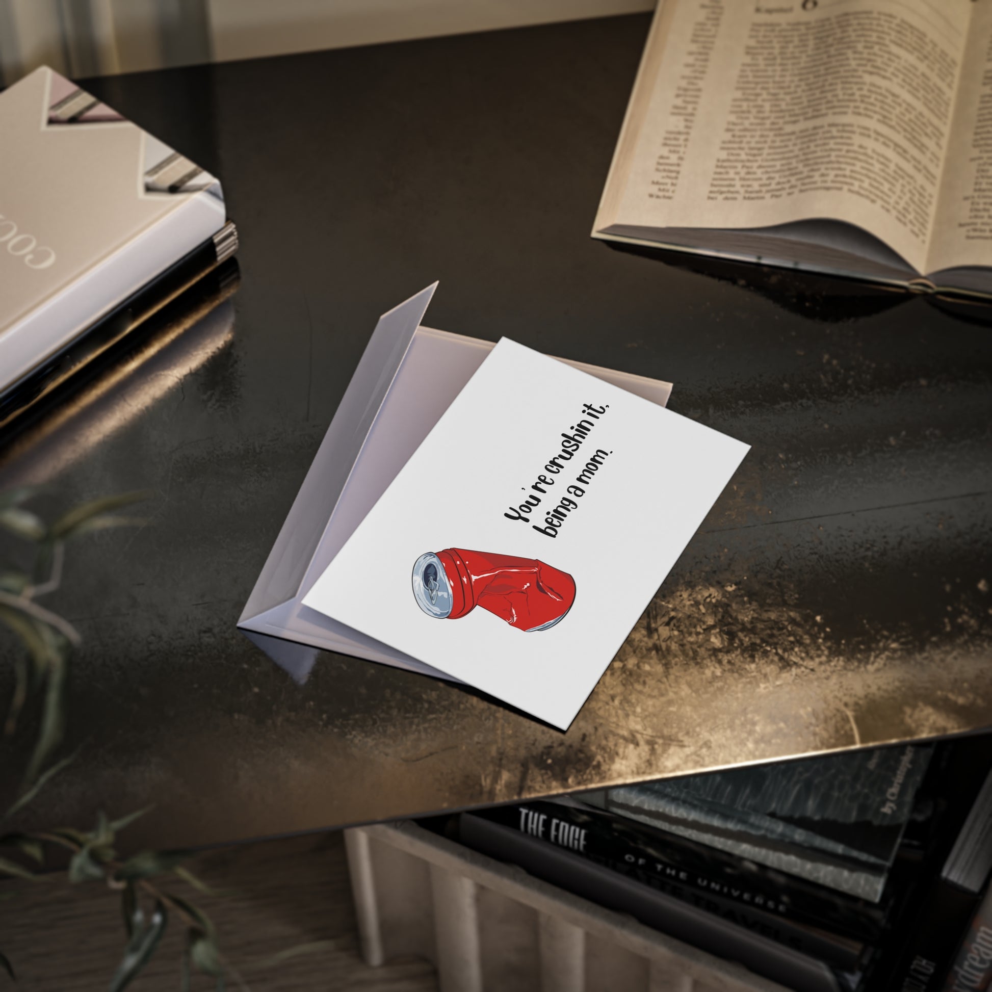 Greeting card with red boxing glove illustration on a dark surface with books and a plant.