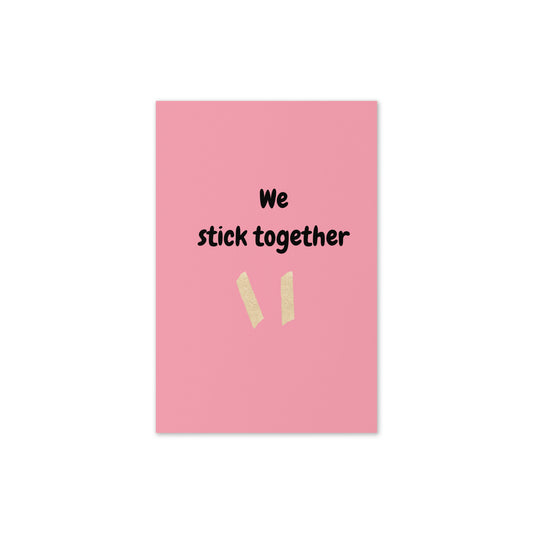 Pink card with 'We stick together' text and two beige stickers on a white background
