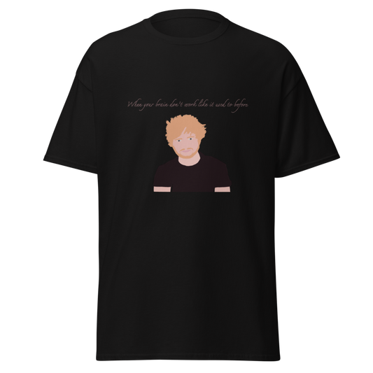 A black short-sleeve crewneck t-shirt featuring a graphic print of a stylized cartoon illustration of a man with orange hair and a beard, with the text 'When your brain doesn't work like it should and it does' printed above.