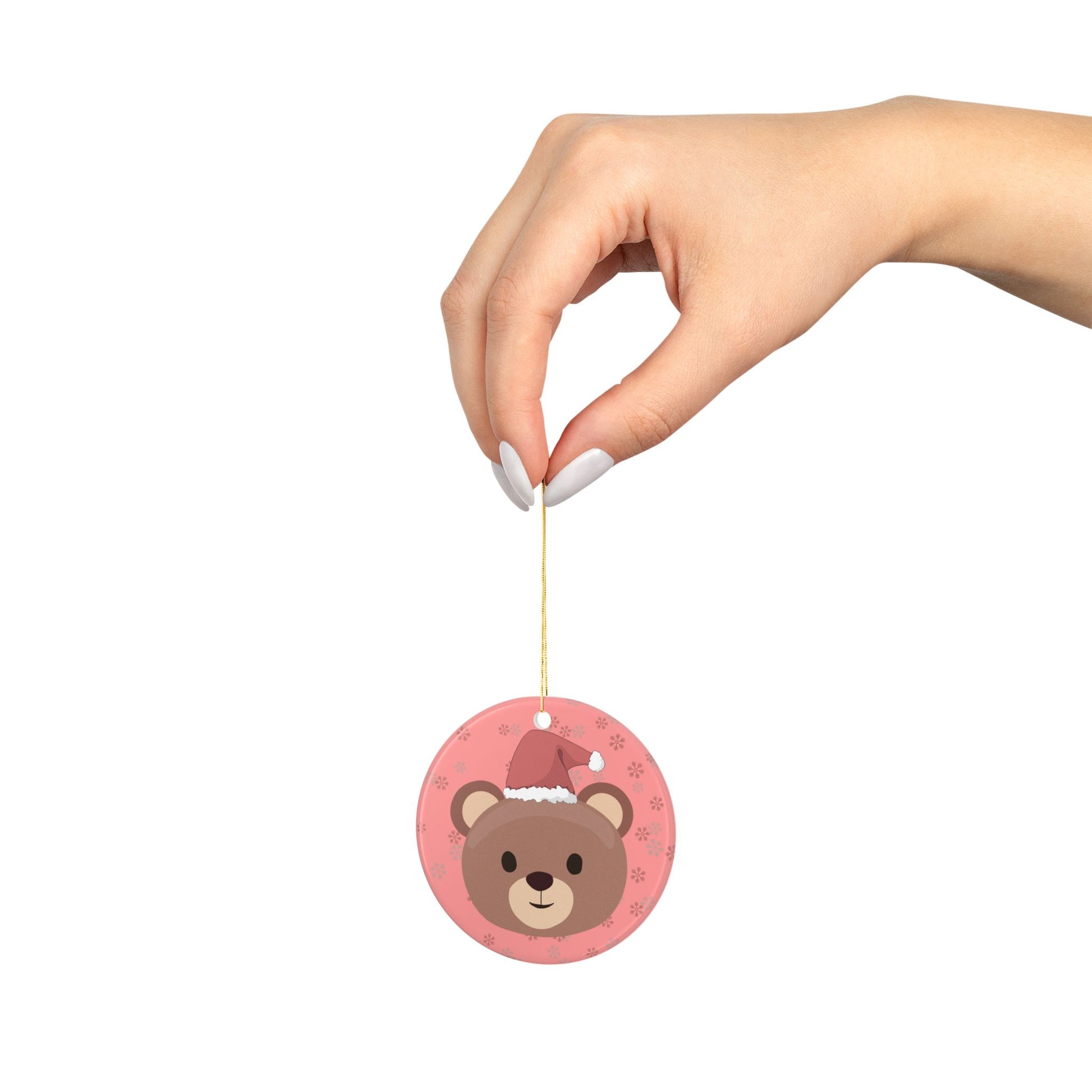 Hand holding a bear-shaped ornament with a white background